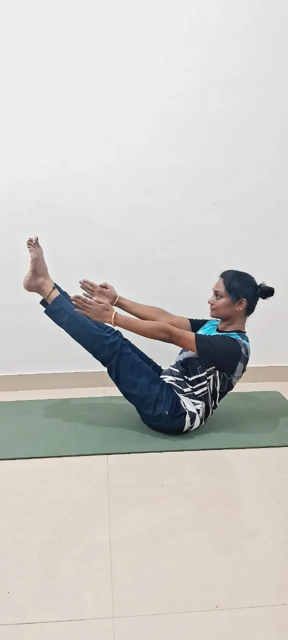 Balancing in boat pose, arms extended forward